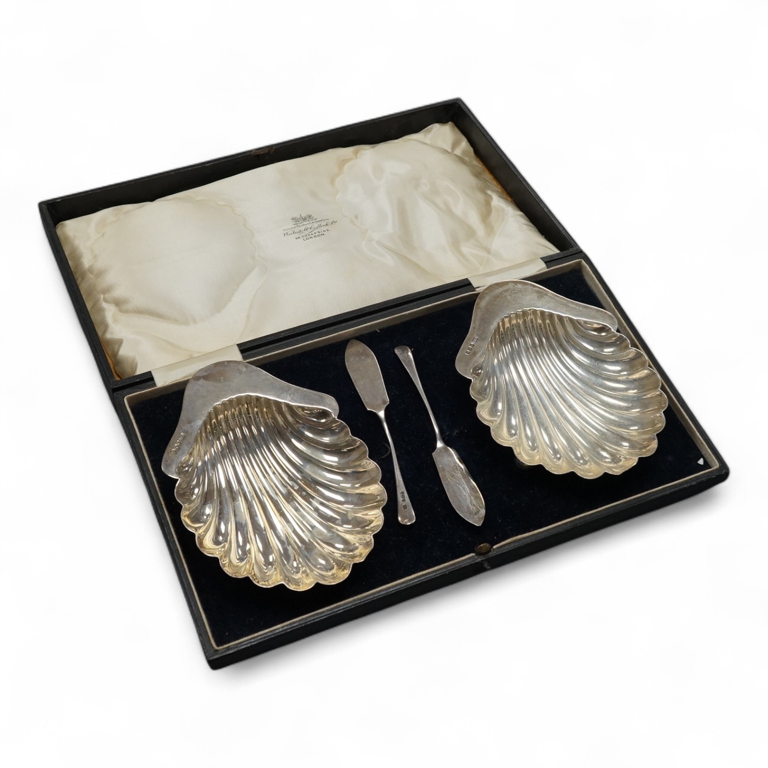 A cased pair of George V silver butter shells, with matching butter knives, George Howson, Sheffield, 1916, shell 13.2cm. Condition - fair to good